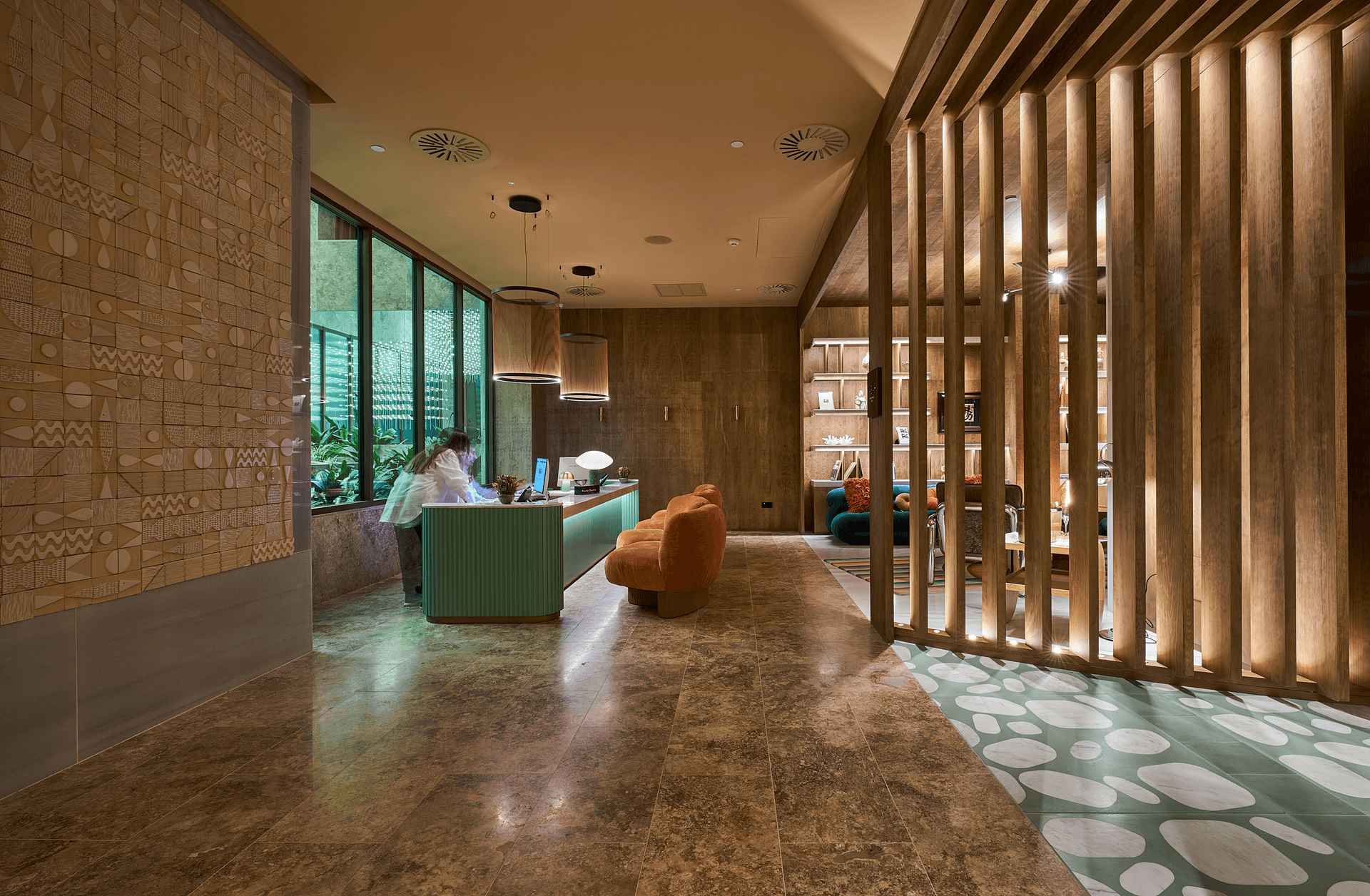 Lobby y zona de recepción del ME by Meliá Málaga Lobby del hotel ME by Meliá Málaga con lamas de madera, iluminación cálida, ventanales de marca STRUGAL y recepción de diseño contemporáneo
