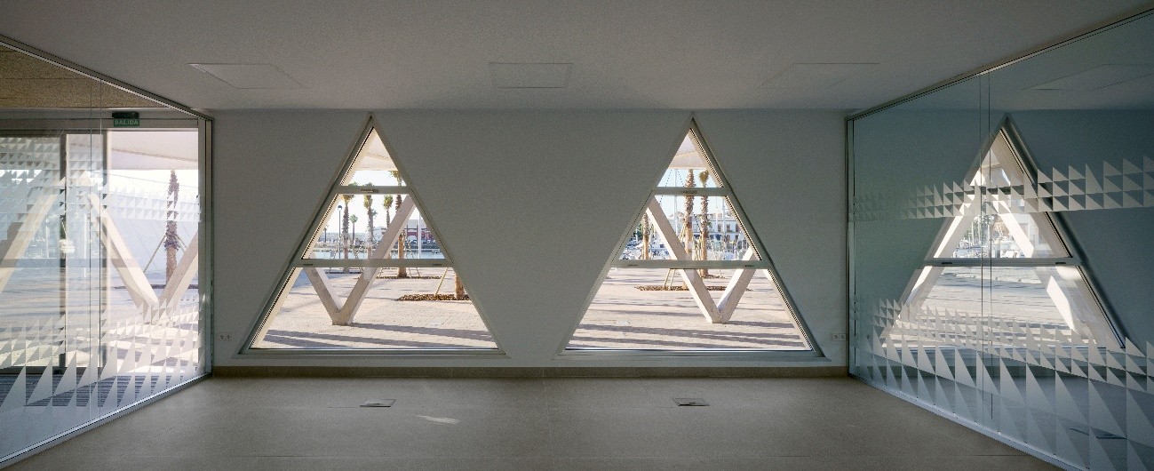 Vista interior del Edificio Polivalente del Puerto de Ayamonte a través de sus ventanas triangulares.